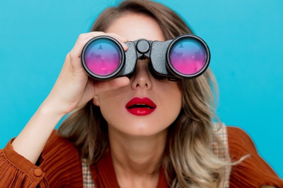 agencia-de-seo-blog Mulher procurando formas de como contratar uma agência de SEO usando um binóculos