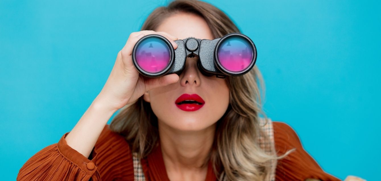 agencia-de-seo-blog Mulher procurando formas de como contratar uma agência de SEO usando um binóculos